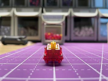 A glittery, crystalline deep ruby switch with a yellow stem